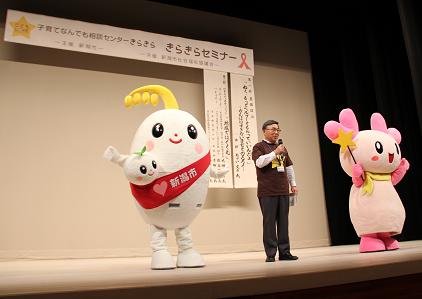 写真：きらきらセミナーのステージ上に立つほのわちゃん、福祉部長、きらりん