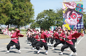 大凧の前でよさこいを披露するダンスチームの写真