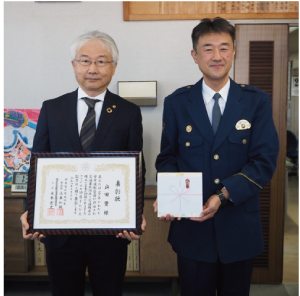 「関東管区警察局長・関東安全運転管理者協議会連合会長 連名表彰」に表彰された山田豊さんが表彰状を持って、新潟南署長と一緒に写っている写真