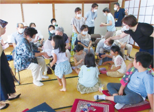 地域の茶の間で子どもと高齢者が一緒に遊んでいる写真