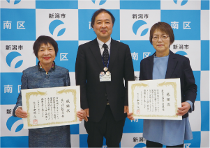 「花いっぱい虹の会」「新潟みなみ商工会　女性支部」の代表者と五十嵐区長の集合写真