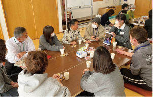 館会場で白高生と地域の人たちがテーブルを囲み談笑している写真