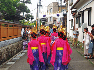 女の子たちがお祭りの衣装を着て町を歩く写真