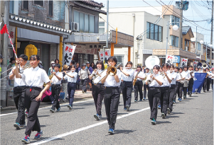 市中パレードで吹奏楽部がマーチングをしている写真