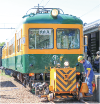 出発前、かぼちゃ電車と鉄道車両用車両移動機「アント」をかぼちゃ電車保存会のメンバーが点検している写真